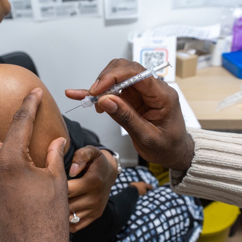 A COVID-19 booster being given by a MediPill pharmacist